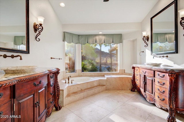 full bath featuring two vanities, a garden tub, tile patterned flooring, and a sink