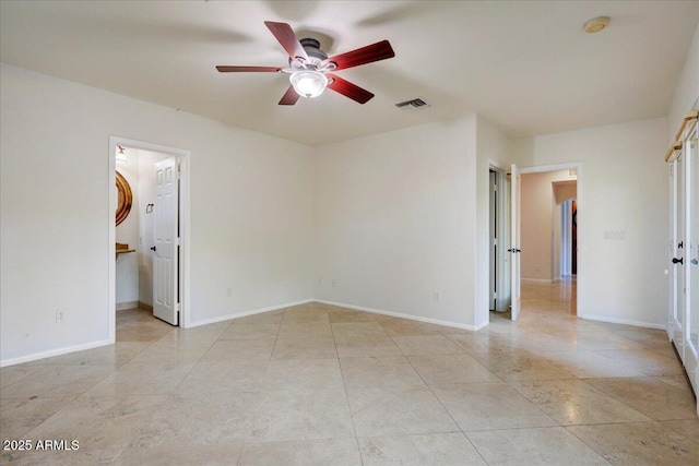 empty room with visible vents, a ceiling fan, baseboards, and light tile patterned floors