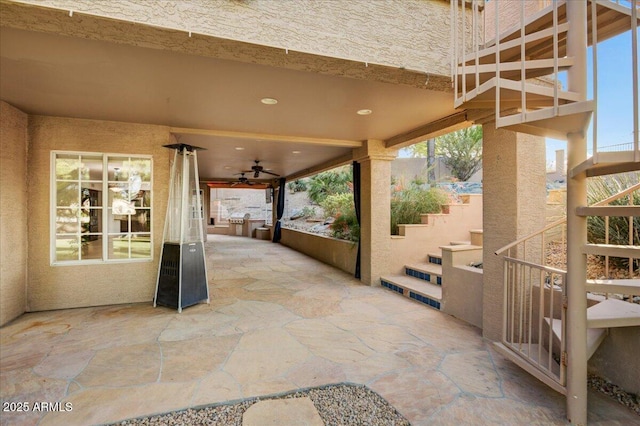 view of patio / terrace with a ceiling fan and stairs