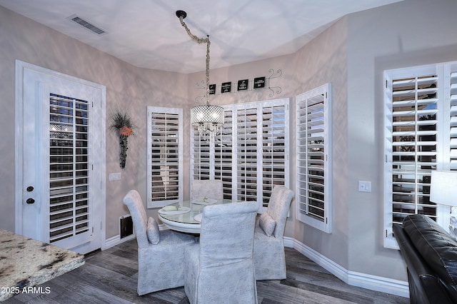 dining area featuring dark wood-style floors, visible vents, and baseboards