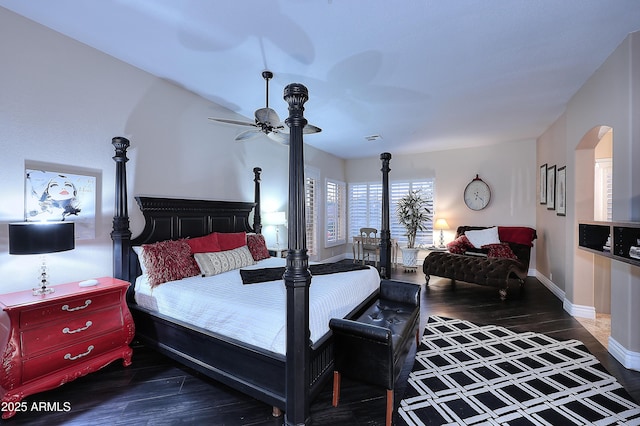 bedroom with baseboards, visible vents, arched walkways, and dark wood finished floors