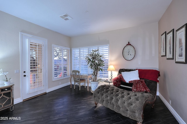 living area featuring dark wood-style floors, visible vents, and baseboards