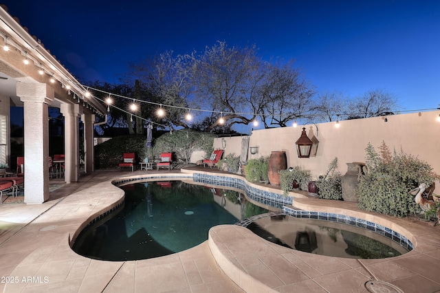 view of pool with a patio area, a fenced backyard, and a pool with connected hot tub