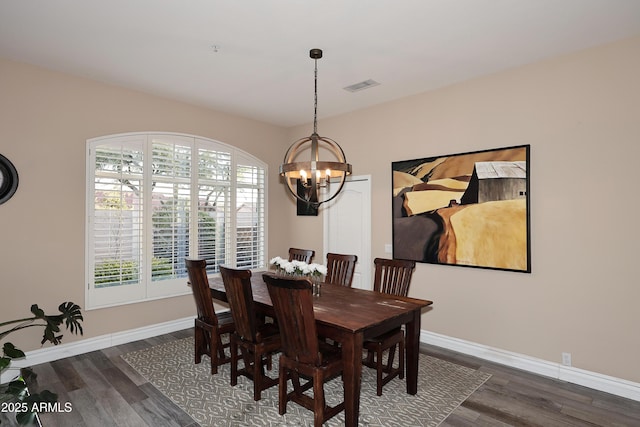 dining room with dark wood-style floors, baseboards, visible vents, and an inviting chandelier