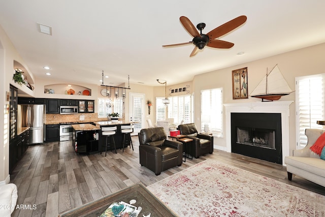 living area with ceiling fan, a fireplace, wood finished floors, and recessed lighting