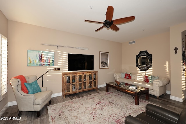 living area with a ceiling fan, dark wood finished floors, and baseboards