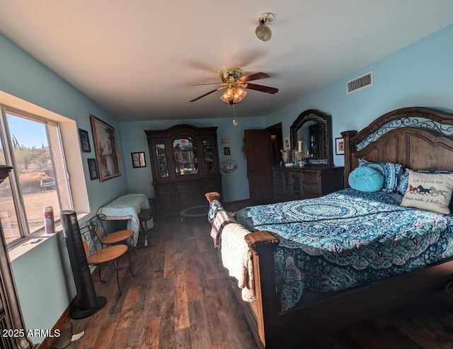 bedroom featuring a ceiling fan, baseboards, visible vents, and wood finished floors