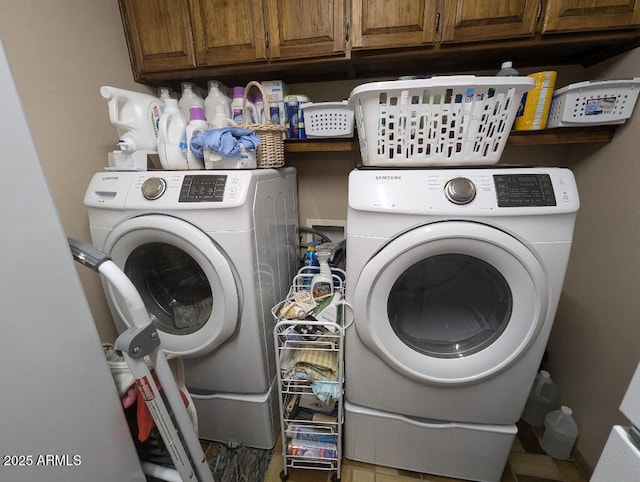 clothes washing area with washer and clothes dryer and cabinet space