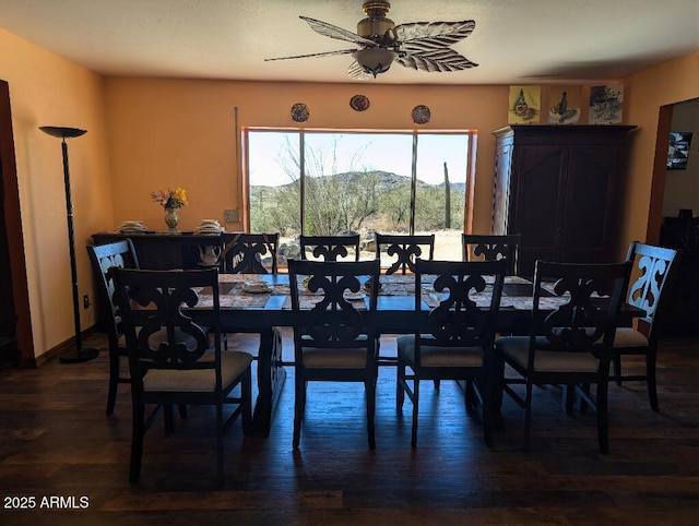 dining space featuring wood finished floors, a mountain view, and a ceiling fan