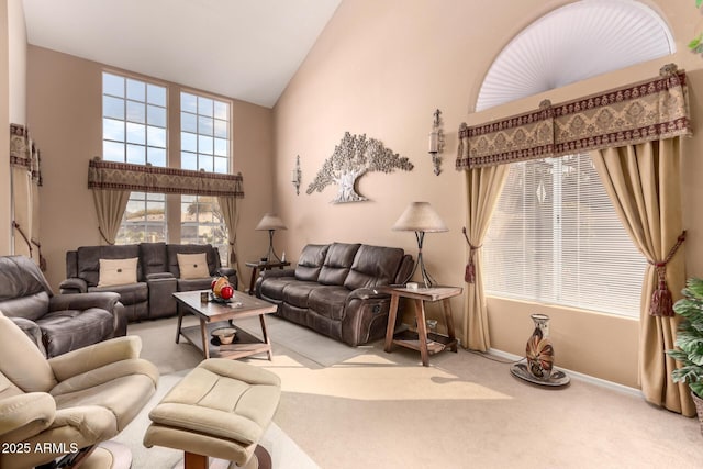 living room with a high ceiling and light carpet