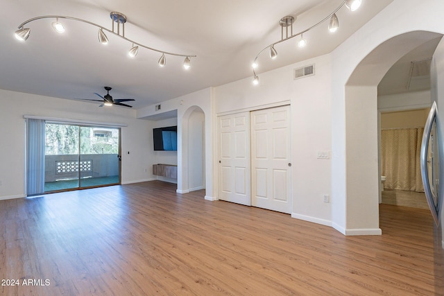 unfurnished living room featuring ceiling fan and light wood-type flooring