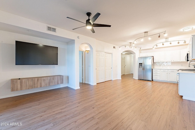 kitchen with light wood-type flooring, stainless steel appliances, white cabinetry, and sink