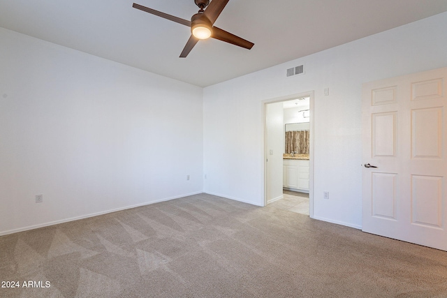 spare room featuring ceiling fan and light colored carpet