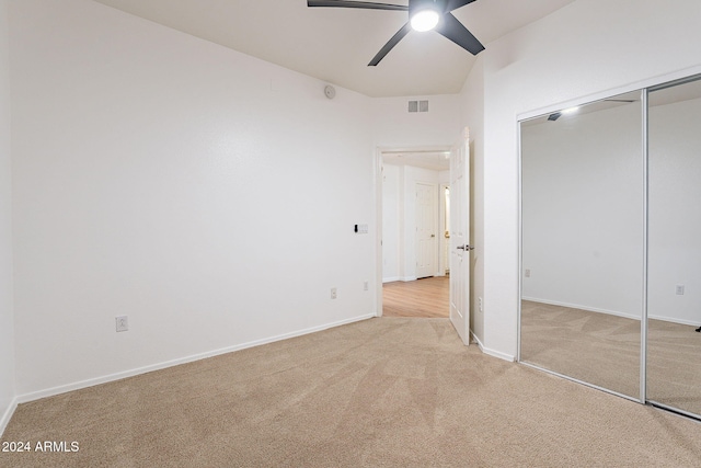 unfurnished bedroom with ceiling fan, a closet, and light colored carpet