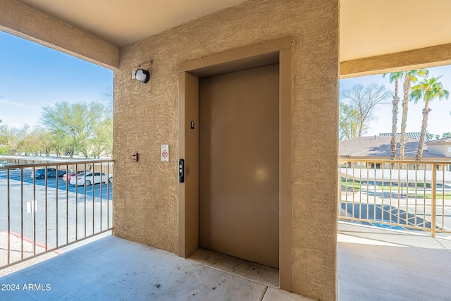 entrance to property featuring elevator and a balcony