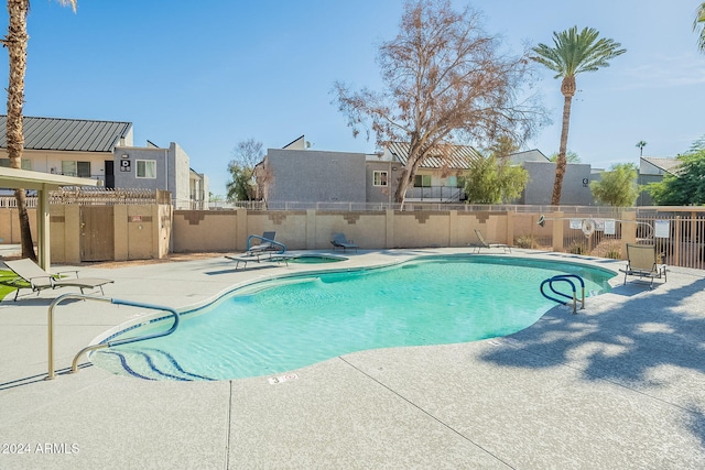 view of swimming pool with a patio and a hot tub