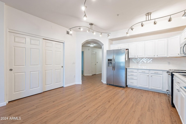 kitchen with light wood-type flooring, white cabinetry, backsplash, and appliances with stainless steel finishes