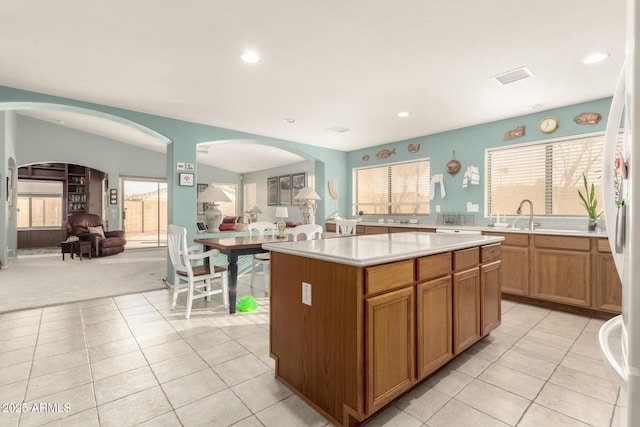 kitchen featuring light tile patterned floors, a center island, and a healthy amount of sunlight