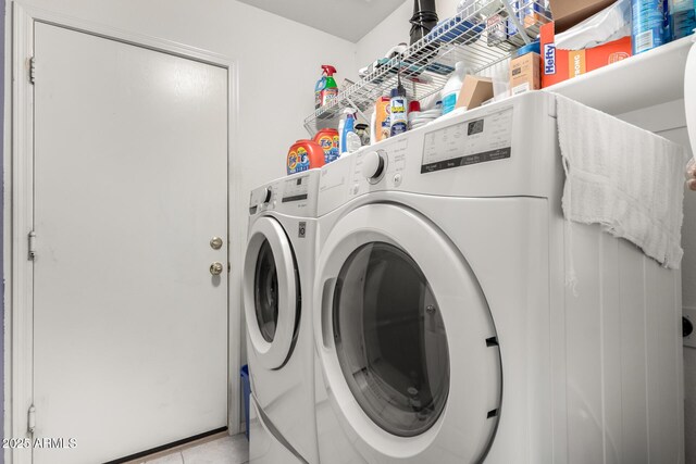 laundry room featuring washer and clothes dryer and light tile patterned floors