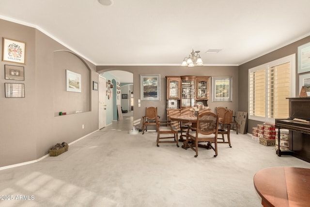 carpeted dining area with ornamental molding and a notable chandelier