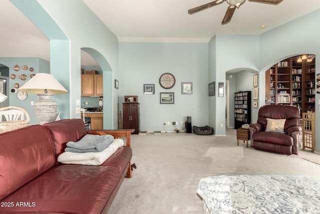 living room featuring ceiling fan, built in features, and light colored carpet