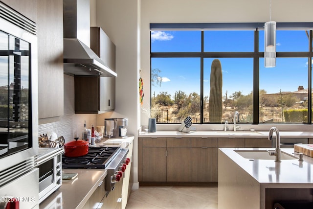 8145 E Tecolote Cir, Scottsdale, AZ 85266 - kitchen featuring backsplash, light countertops, a sink, and wall chimney range hood