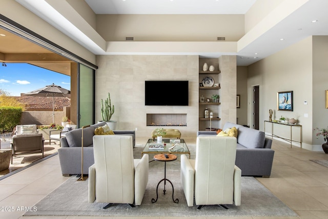 8145 E Tecolote Cir, Scottsdale, AZ 85266 - living room featuring a high ceiling, light tile patterned floors, a fireplace, and visible vents