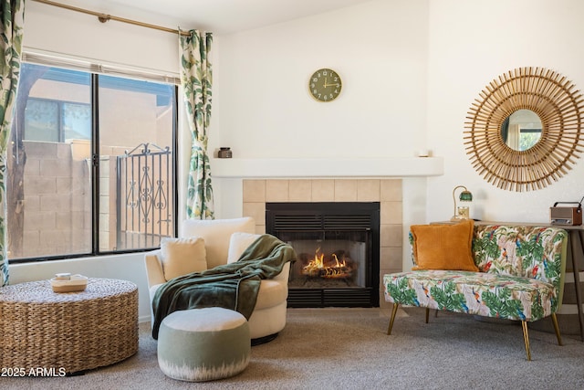 sitting room with carpet flooring and a tiled fireplace