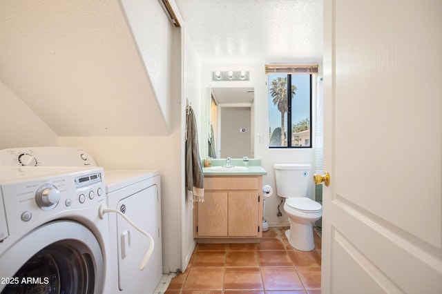 laundry area featuring a sink, laundry area, light tile patterned floors, and washer and dryer