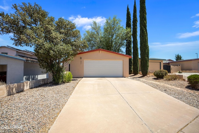 view of front of property featuring concrete driveway, an attached garage, and stucco siding