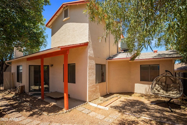 rear view of house with a patio and stucco siding