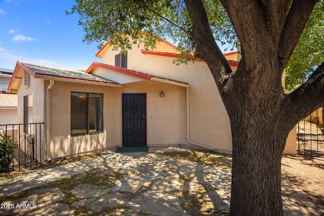 view of front of property with a patio area, stucco siding, and fence