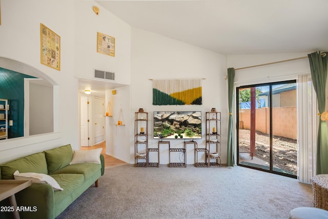 carpeted living area with high vaulted ceiling and visible vents