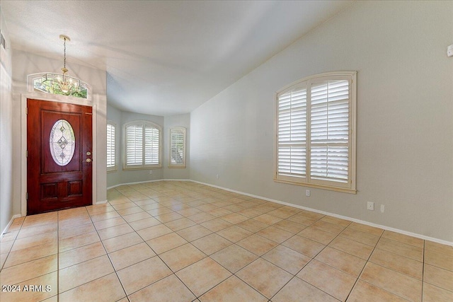 tiled foyer with a chandelier