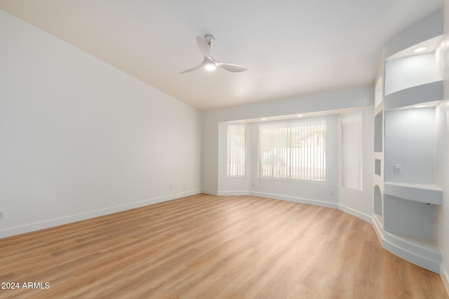 spare room featuring light hardwood / wood-style floors, vaulted ceiling, and ceiling fan