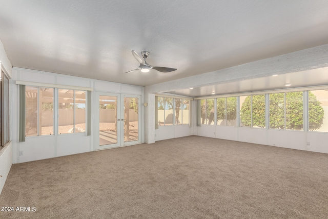 unfurnished sunroom with ceiling fan and a healthy amount of sunlight