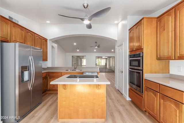 kitchen featuring stainless steel appliances, ceiling fan, sink, light hardwood / wood-style flooring, and a kitchen island