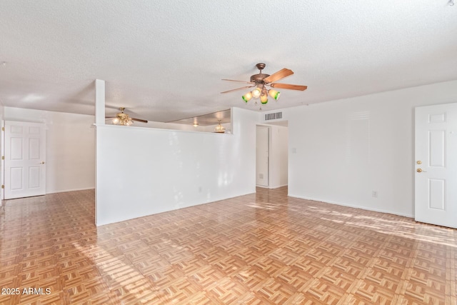 empty room with a textured ceiling, light parquet flooring, and ceiling fan