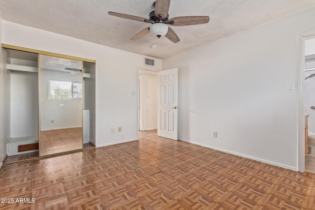 unfurnished bedroom featuring ceiling fan, a textured ceiling, and light parquet floors