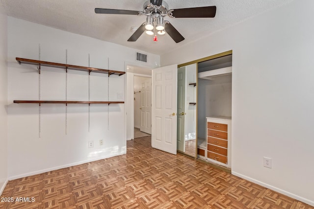 unfurnished bedroom featuring a textured ceiling, a closet, light parquet floors, and ceiling fan