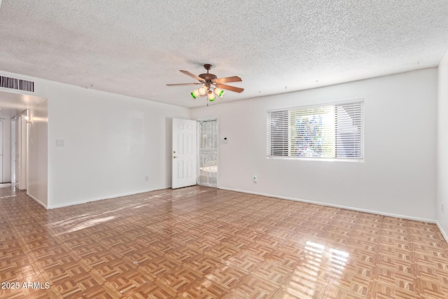 unfurnished room featuring a textured ceiling, light parquet floors, and ceiling fan