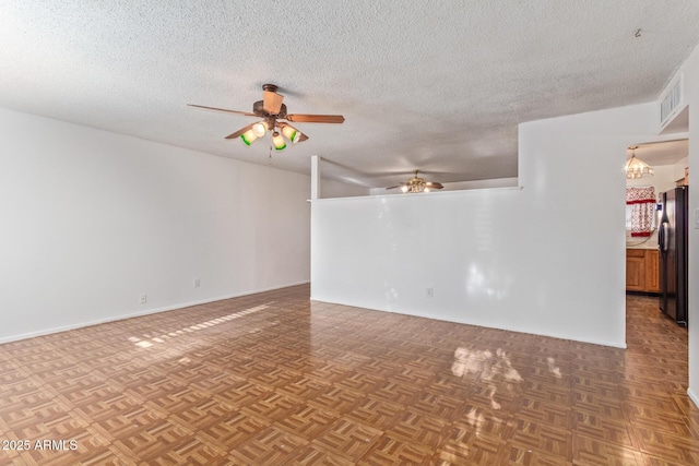 unfurnished room featuring ceiling fan with notable chandelier, parquet floors, and a textured ceiling