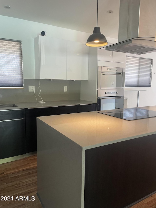 kitchen featuring island exhaust hood, pendant lighting, white cabinets, and a center island