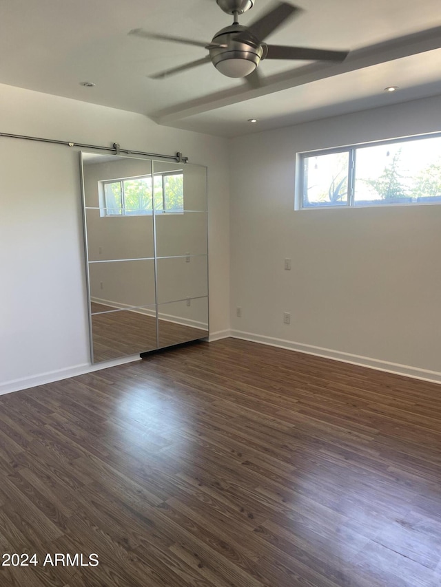 unfurnished bedroom featuring ceiling fan, dark hardwood / wood-style flooring, and a closet