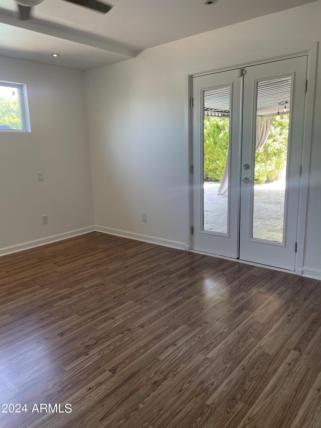 spare room featuring french doors and dark wood-type flooring