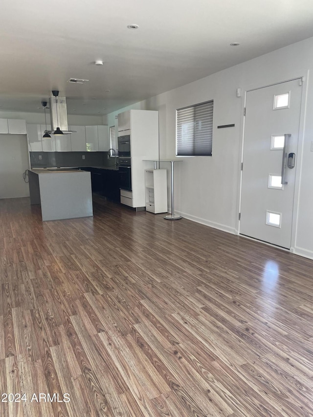 unfurnished living room featuring dark hardwood / wood-style flooring and sink