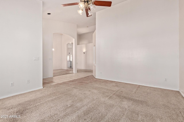 871 W Mesquite St, Gilbert, AZ 85233 - empty room featuring light colored carpet, ceiling fan, arched walkways, and light tile patterned floors