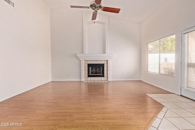 871 W Mesquite St, Gilbert, AZ 85233 - unfurnished living room with light wood finished floors, ceiling fan, a tiled fireplace, and high vaulted ceiling