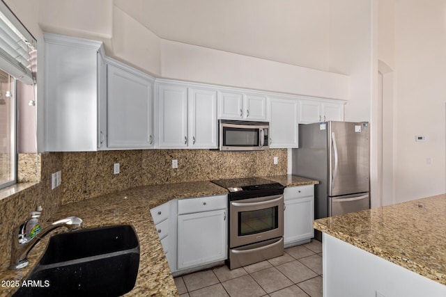 871 W Mesquite St, Gilbert, AZ 85233 - kitchen featuring stainless steel appliances, white cabinetry, backsplash, light tile patterned floors, and light stone counters