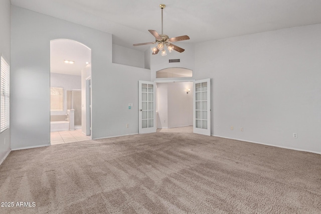 871 W Mesquite St, Gilbert, AZ 85233 - unfurnished room featuring arched walkways, carpet, french doors, a ceiling fan, and a high ceiling